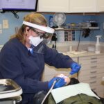 dental assistant Stacy Croston examines patient Mikhail Conrad